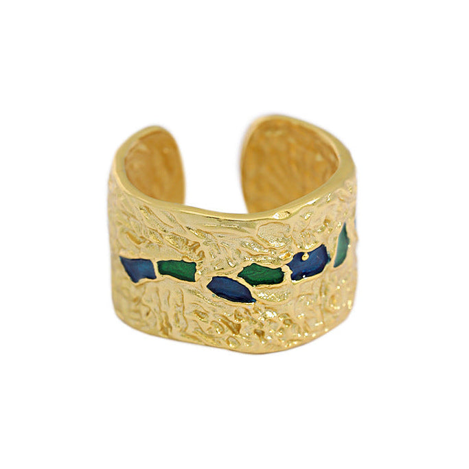 Gold ring with blue and green accents on a white background