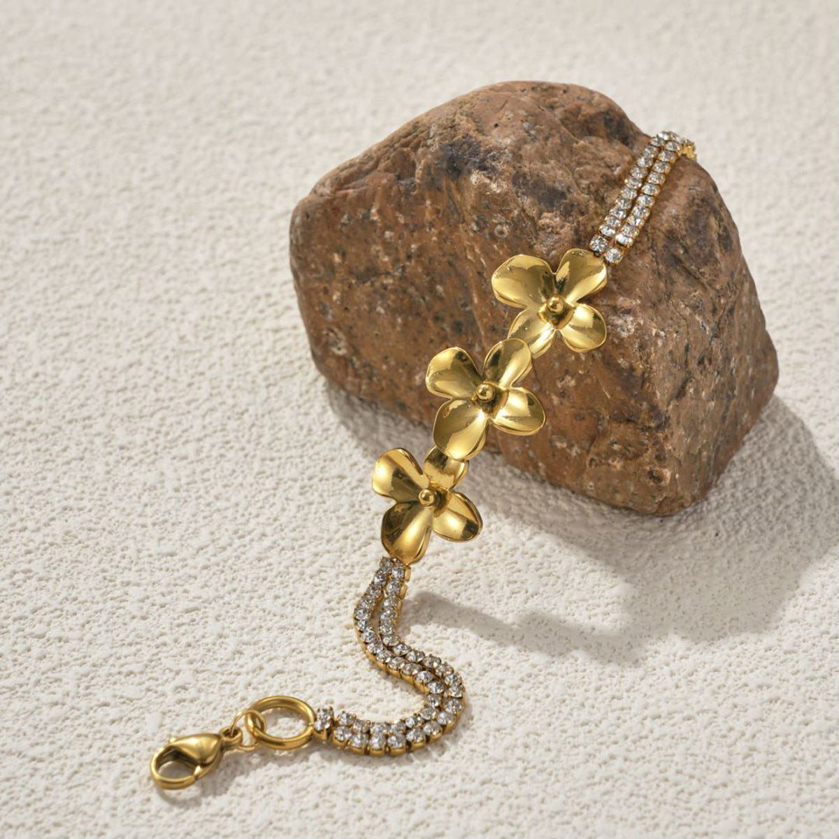 18K Gold Plated Stainless Steel Flower Bracelet  on a stone withe background 